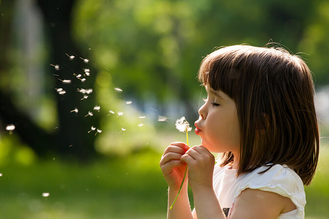 Kind mit Pusteblume Allergien